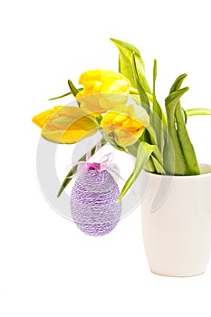 Yellow tulips in white vase with easter egg