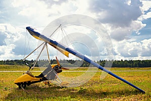 Yellow ultralight trike is parked on the earth