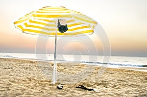 Yellow umbrella lonely on the beach at sunset in Puglia