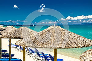 Yellow umbrellas on beach, blue paradise water, Halkidiki, Greece