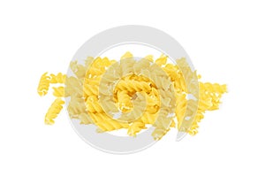 Yellow uncooked fusilli pasta heap isolated on white background.