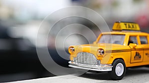 Yellow vacant mini taxi cab close up, Harmon corner, Las Vegas, USA. Small retro car model on defocused background