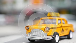 Yellow vacant mini taxi cab close up, Harmon corner, Las Vegas, USA. Small retro car model on defocused background. Little iconic