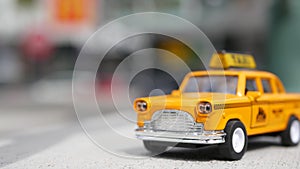 Yellow vacant mini taxi cab close up, Harmon corner, Las Vegas, USA. Small retro car model on defocused background. Little iconic