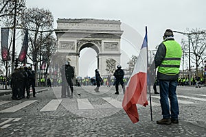 Yellow vests - Gilets jaunes protests - Protester holding a french flag stands in front of riot police