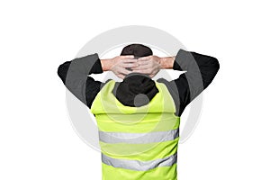 Yellow vests protests. Young man stands with his back and holds his hands on his head on isolated