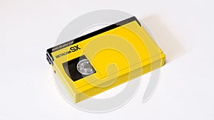 Yellow videocassette with dark shutter betacam sx format on white background