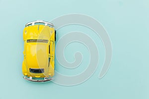 Yellow vintage retro toy car isolated on blue pastel colorful background