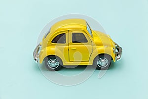 Yellow vintage retro toy car isolated on blue pastel colorful background