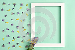 Yellow and violet petals and flowers, photo frame on a green background.