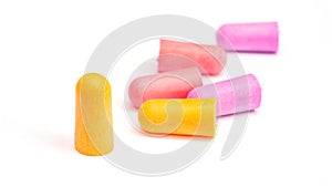 Yellow, violet and pink earplugs on a white background