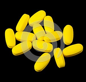 Yellow Vitamin Pills on Black Background