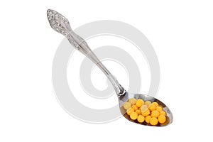 Yellow vitamins on spoon