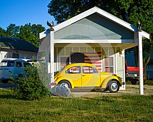 Yellow Volkswagon Bug in front of American Flag