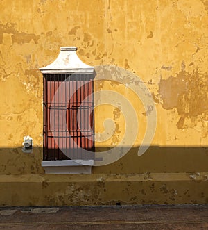 Yellow wall with barred window