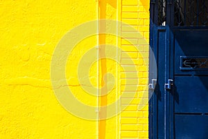 Yellow wall and blue metal door