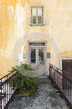 Yellow wall with door and window with shutters in Auronzo di Cadore, beautiful tourist mountain town in the Dolomites