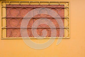 Yellow wall with trellised battened window.  Round elements of rack bar. Industrial construction closeup view with copy space