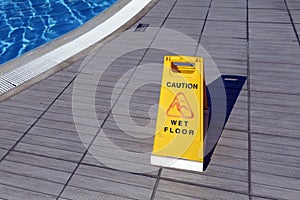 Yellow warning sign: Ñaution, wet floor