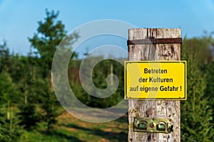 Yellow warning sign with German text `Entering the crops at your own risk`