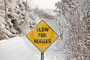 A Yellow Warning Sign reading Slow for Horses