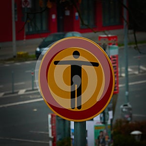 Yellow warning sign with a red circle and a black figure with spread out arms, which forbids access to the building