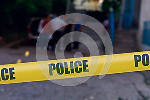 Yellow warning tape with the words Police on a blurred background of the crime scene. Crime news template