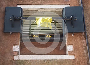 Yellow washing up gloves and cloth hanging out of a window