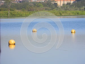 Yellow water buoy floating on calm lake