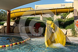 Yellow water slide for children at a resort swimming pool for family vacation and fun