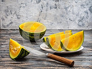 Yellow watermelon in a cut, slices on a plate