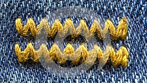 Yellow waves on jeans fabric texture.