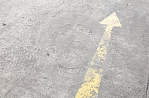 Yellow way arrow pointing symbol on a ground road surface