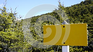 Yellow weathered sign in wooded area