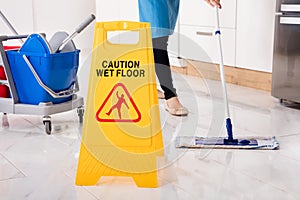 Yellow Wet Caution Sign On Wet Floor In Kitchen