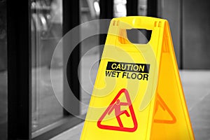 Yellow wet floor sign in a hallway, selective color