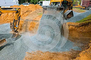 Yellow wheel unloading gravel at construction work equipment machinery for construction of foundation
