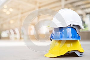 Yellow,white,blue hard safety wear helmet hat in the project at construction site