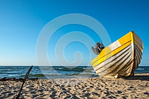 A yellow white boats on beautiful beach