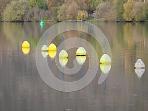 Yellow and white buoys floating in the current on the water surface of a river