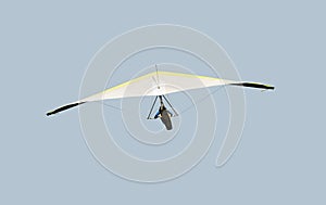 Yellow and white hang glider in flight off,isolated on light blue