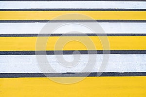 Yellow-white pedestrian crossing on asphalt. Close-up of the road