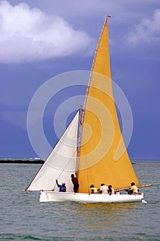 Yellow and white sailed pirogue
