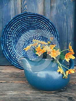 Yellow wild flowers in blue clay pot