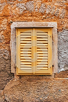 Yellow window shutters of an old house in Lovran