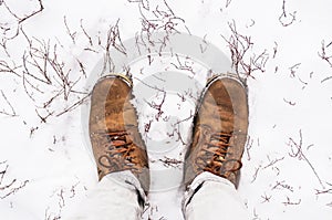 Yellow winter boots in white snow in frost