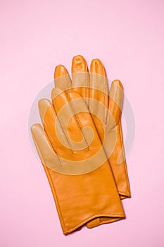 Yellow women`s gloves made of soft leather on a pink