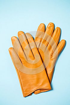 Yellow women`s gloves made of soft leather on a pink