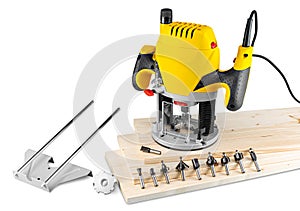 Yellow wood router machine with cutter bits guide and copy ring on wooden spruce planks isolated white background. carpentry