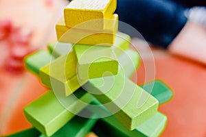 Yellow wooden blocks in balance in a toy tower